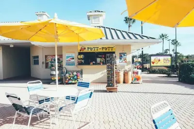 a table and chairs with yellow umbrellas in front of a store at Near Disney 1BD vacation condo in beautiful resort with lots of amenities in Orlando