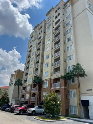 a large apartment building with cars parked in a parking lot at 1 Bedroom - Grand Suite 5 min to Universal, I-drive & Outlets in Orlando