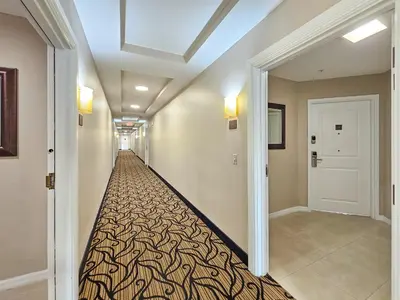 a hallway with a long hallway with a carpet at 1 Bedroom - Grand Suite 5 min to Universal, I-drive & Outlets in Orlando