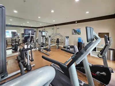 a gym with a bunch of tread machines in it at 1 Bedroom - Grand Suite 5 min to Universal, I-drive & Outlets in Orlando
