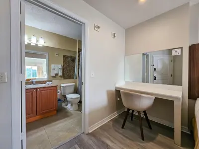 a bathroom with a sink and a toilet and a mirror at Double King Bed Suite, 5 Min from Universal, I-Drive & Outlets in Orlando