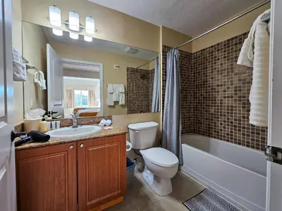 a bathroom with a toilet and a sink and a bath tub at Double King Bed Suite, 5 Min from Universal, I-Drive & Outlets in Orlando