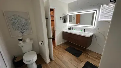 a bathroom with a toilet and a sink and a mirror at New APT 15Min Drive Disney and Airport - Parks KingBed Pets in Kissimmee