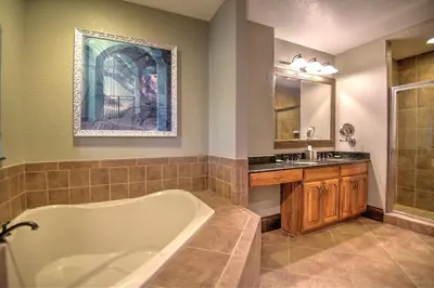 a bathroom with a tub and a sink at Beautiful Resort in Bonnet Creek 2BD Deluxe near Walt Disney World in Orlando