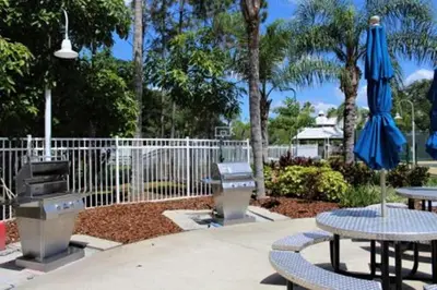 a patio with two tables and an umbrella at Diamond - Cypress Pointe Resort - St in Orlando