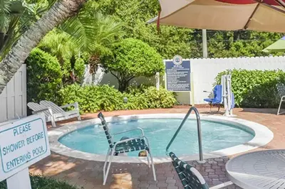 a swimming pool with chairs and a table and an umbrella at Diamond - Cypress Pointe Resort - 2BD in Orlando
