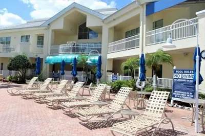 a group of chairs and umbrellas in front of a hotel at Diamond - Cypress Pointe Resort - 2BD in Orlando