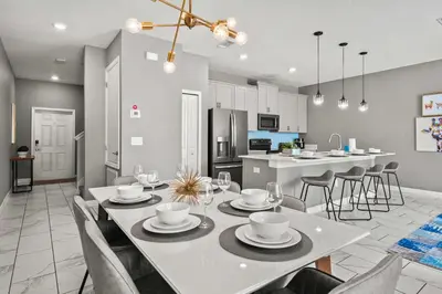 a dining room and kitchen with a white table and chairs at 5003 Windermere Avenue in Kissimmee