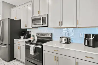 a kitchen with white cabinets and stainless steel appliances at 5003 Windermere Avenue in Kissimmee