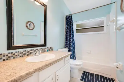 a bathroom with a sink and a toilet and a mirror at Relaxing Retreat with Pool and Movie Theater in Orlando
