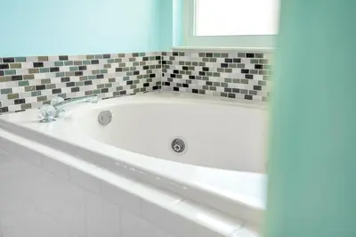 a white bath tub in a bathroom with a window at Relaxing Retreat with Pool and Movie Theater in Orlando