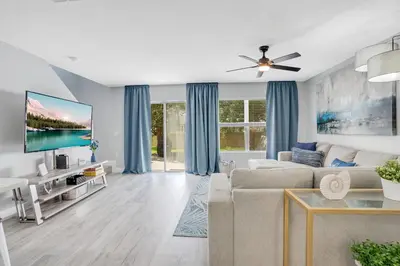 a living room with a couch and a flat screen tv at Stylish Villa Near Disney & Universal in Kissimmee