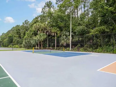 a tennis court with a net on it at Orlando 1BR Disney Themed Vacation with pool view Next to Disney in Kissimmee