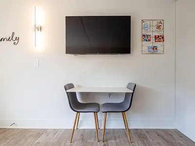 a white table with two chairs and a tv on a wall at Orlando 1BR Disney Themed Vacation with pool view Next to Disney in Kissimmee