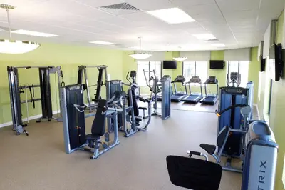 a gym with rows of treadmills and machines at Stylish 2-BR Apt Sleeps 7 Near Disney Magic in Kissimmee