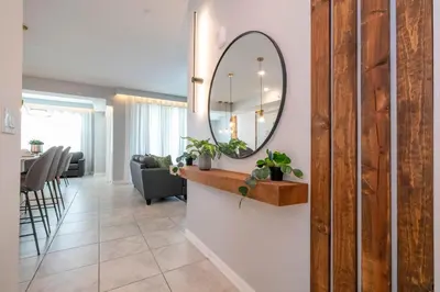 a living room with a mirror on a wall at Stylish 2-BR Apt Sleeps 7 Near Disney Magic in Kissimmee