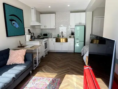 a living room with a couch and a kitchen at Downtown Groovy Studio in Orlando