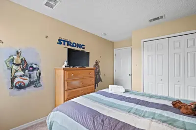 a bedroom with a bed and a tv on a wall at Terra Verde Townhouse with Patio in Kissimmee