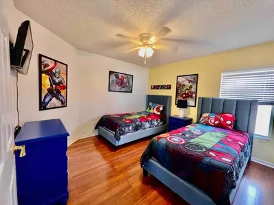 a bedroom with two beds and a ceiling fan at 7BD 5BA w Pool Spa Home 10 mins away to Disney in Kissimmee