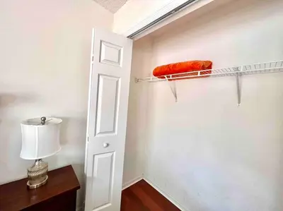 a room with an open door with a red pillow on a shelf at 7BD 5BA w Pool Spa Home 10 mins away to Disney in Kissimmee