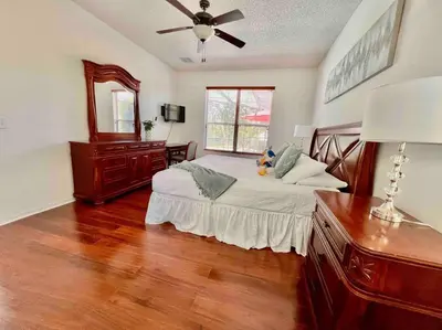a bedroom with a bed and a ceiling fan at 7BD 5BA w Pool Spa Home 10 mins away to Disney in Kissimmee
