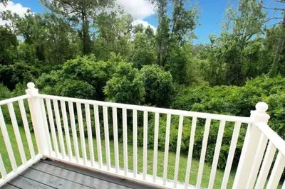 a white wooden deck with trees in the background at Sunkey Disney Home Resort 10 min from the Parks in Kissimmee
