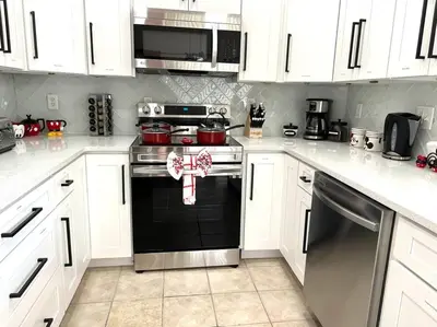 a kitchen with white cabinets and a black oven at Sunkey Disney Home Resort 10 min from the Parks in Kissimmee