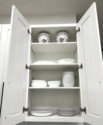 a white cabinet with plates and bowls in it at Sunkey Disney Home Resort 10 min from the Parks in Kissimmee
