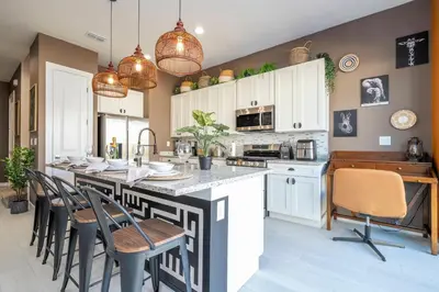 a kitchen with a large kitchen island with chairs at Welcome to The Lion Nest. A Savanna-Inspired Oasis in Orlando