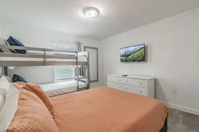 a bedroom with two bunk beds and a tv at Casa luxuosa 4BD/3BA * Storey Lake * in Kissimmee