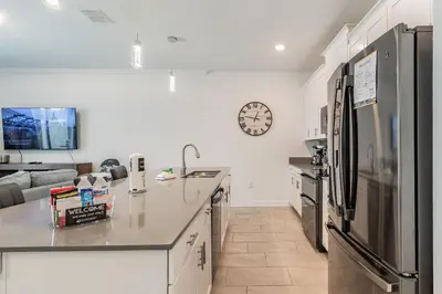 a kitchen with a refrigerator and a counter top at Casa luxuosa 4BD/3BA * Storey Lake * in Kissimmee