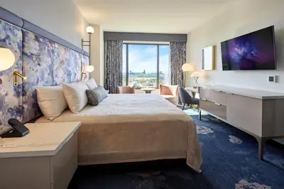 a hotel room with a large bed and a desk at Universal's Helios Grand Hotel, a Loews Hotel in Orlando