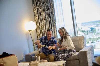 a man and a woman sitting on a couch at Universal's Helios Grand Hotel, a Loews Hotel in Orlando
