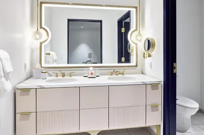 a bathroom with two sinks and a large mirror at Universal's Helios Grand Hotel, a Loews Hotel in Orlando