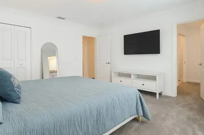 a bedroom with a bed and a tv on a wall at 4Q/3B * Nova e Luxuosa c/Piscina Priv * in Kissimmee