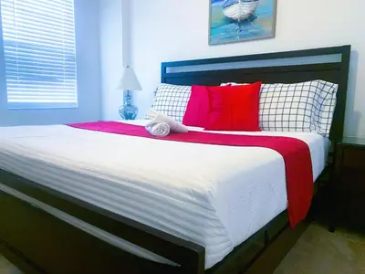 a bedroom with a large bed with red and white pillows at Magic Kingdom Villa - Private Master Bedrooms in Kissimmee