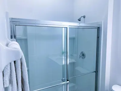 a glass shower in a bathroom with a towel at Magic Kingdom Villa - Private Master Bedrooms in Kissimmee