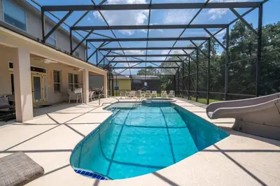 a swimming pool with a glass roof on a patio at Waterslide 6 bed Lux Villa Emerald Island in Kissimmee