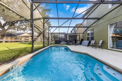 a swimming pool with a patio and a house at 6 Bedroom Villa - Emerald Island Retreat in Kissimmee