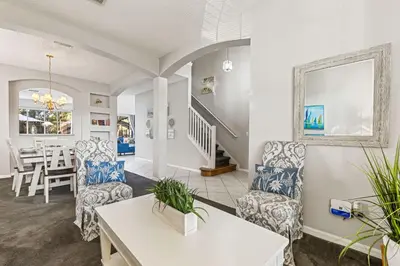 a living room with chairs and a table at 6 Bedroom Villa - Emerald Island Retreat in Kissimmee