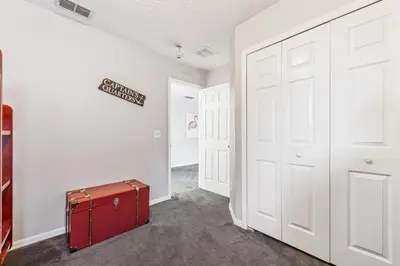 a red suitcase sitting in a hallway next to a door at 6 Bedroom Villa - Emerald Island Retreat in Kissimmee