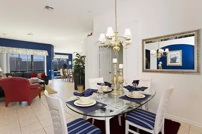 a dining room and living room with a table and chairs at Just 3 miles from Disney! in Kissimmee