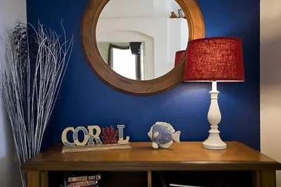 a table with a lamp and a mirror on it at Just 3 miles from Disney! in Kissimmee