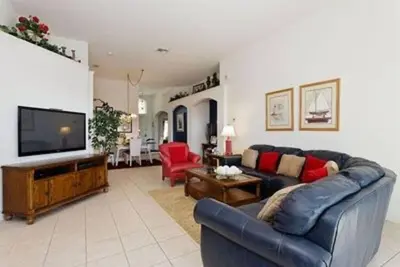 a living room with a couch and a flat screen tv at Just 3 miles from Disney! in Kissimmee