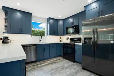 a large kitchen with blue cabinets and a window at Luxury Villa Near Disney I Fully Renovated in Kissimmee