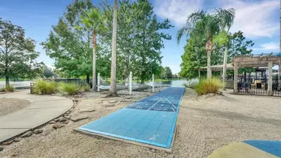 a blue boardwalk in a park with palm trees at Summer Getaway - 5-Bedroom Home with Private Pool! in Kissimmee