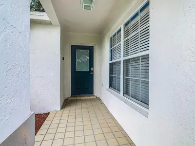 a hallway with a blue door and a window at Dreamy 5BR, 3Bath Getaway, Pool, Spa, Near Disney in Orlando