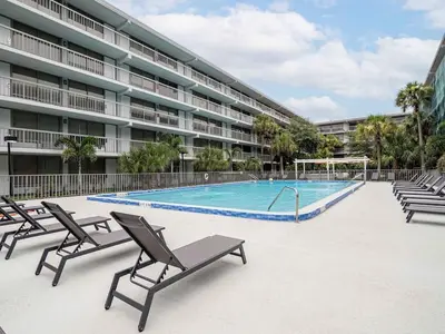 a swimming pool in front of a large building at Luxury Orlando Condo Next to Disney with lake view in Kissimmee