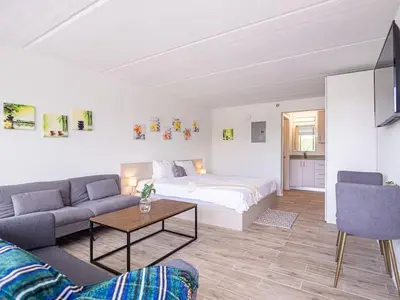 a living room with a bed and a couch at Luxury Orlando Condo Next to Disney with lake view in Kissimmee