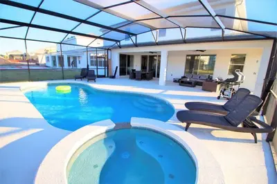 a swimming pool with chairs and a house at 3841 Kalistoga Stylish Villa 7BD Private Pool and Game Room in Kissimmee